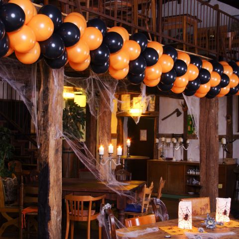 Halloween-Luftballongirlande in schwarz-orange als deko in einem geschmückten Restaurant.